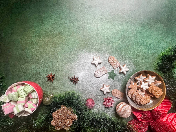 Galletas y decoraciones navideñas sobre un fondo verde - Foto, Imagen