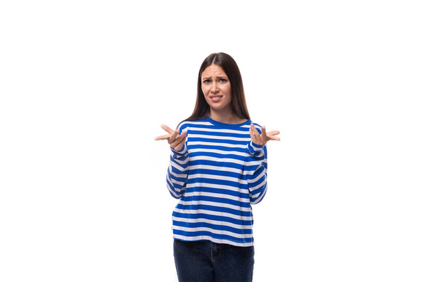 Młoda kobieta rasy kaukaskiej z ciemnymi włosami ubrana w niebieską bluzę w paski na białym tle. koncepcja stylu życia ludzi. - Zdjęcie, obraz