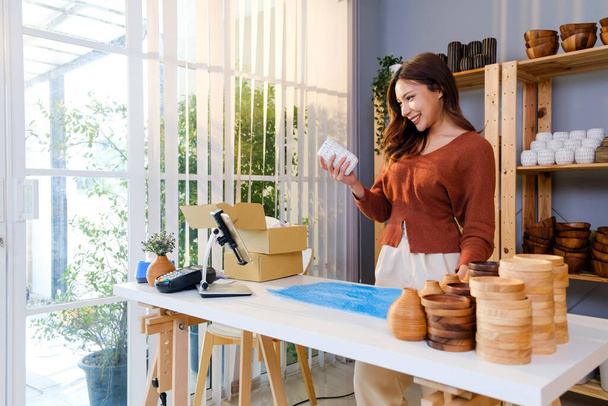 小包に送る前に、脆弱な製品のための気泡ラップを花瓶に詰めアジアの女性。彼女のオンラインストアから購入した顧客に送る準備ができています。ショッピングオンラインコンセプト. - 写真・画像