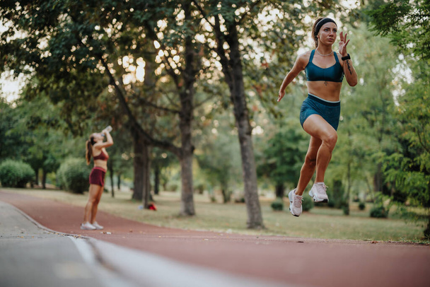 Вмістити дівчат у спортивний одяг бігати на відкритому повітрі в зеленому парку. Їх мотивовані вирази надихають здоровий спосіб життя, демонструючи красу природи та переваги активної рутини вправ. - Фото, зображення