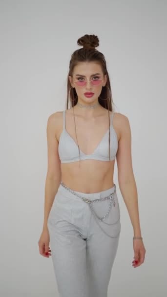 Sexy giovane modella donna in reggiseno e pantaloni è fotografato in studio con fotografo su sfondo bianco. - Filmati, video