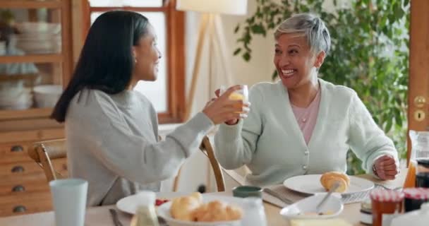 Hug, women and breakfast cheers in a family home with orange juice at table for health and wellness. A mother, people or friends together in dining room with love, care and conversation about food. - Footage, Video