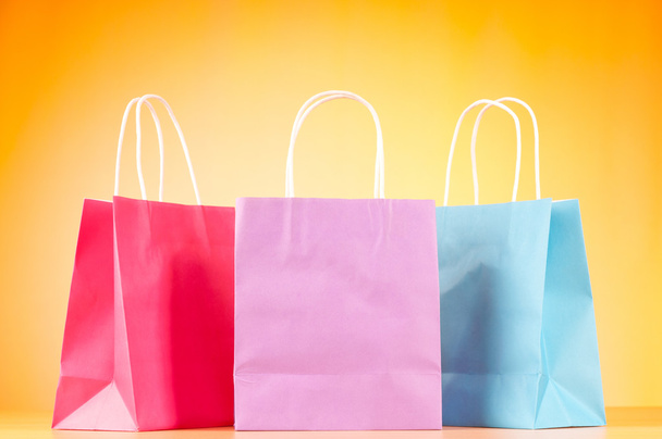 Цветные бумажные пакеты для покупок на фоне градиента
 - Фото, изображение