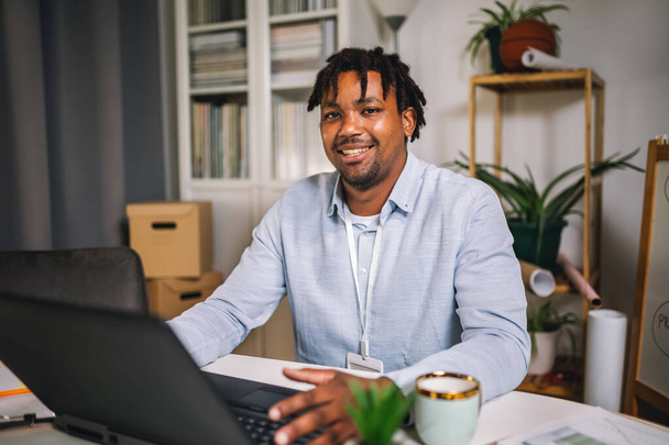 Handsome African American smiling freelancer working remotely from home - Photo, Image