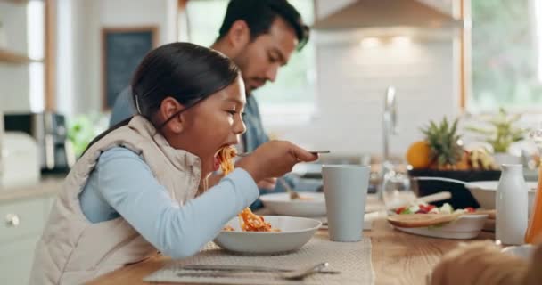Apa, gyerekek és egy lány együtt eszik spagettit a családjával az otthonuk ebédlőjében vacsorára. Étel, lány gyermek és apa egy asztalnál egy ebédre, kötődés vacsora közben egy házban. - Felvétel, videó