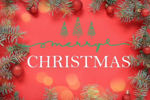 Ευχετήρια κάρτα με μπάλες Χριστουγέννων και κλαδιά ελάτης σε κόκκινο φόντο - Φωτογραφία, εικόνα