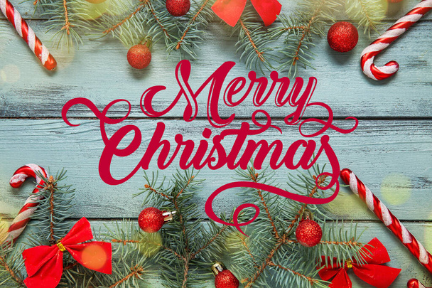 Ευχετήρια κάρτα με χριστουγεννιάτικες διακοσμήσεις και κλαδιά ελάτης σε ξύλινο φόντο - Φωτογραφία, εικόνα