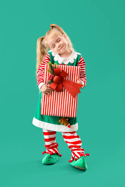 Sonhando pequeno elfo com presente de Natal no fundo verde - Foto, Imagem