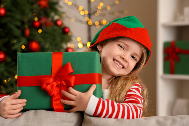Cute little elf with Christmas gift at home - Photo, Image