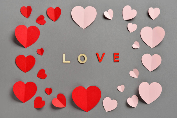 Composição romântica com corações de papel vermelho e rosa sobre fundo cinza. Dia de São Valentim. - Foto, Imagem