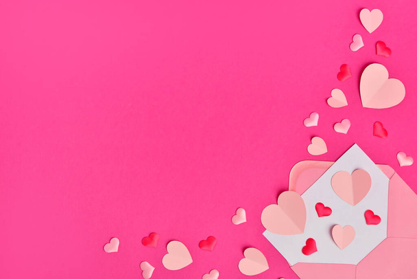 Composición con diferentes corazones de papel y sobre sobre fondo rosa - Foto, Imagen