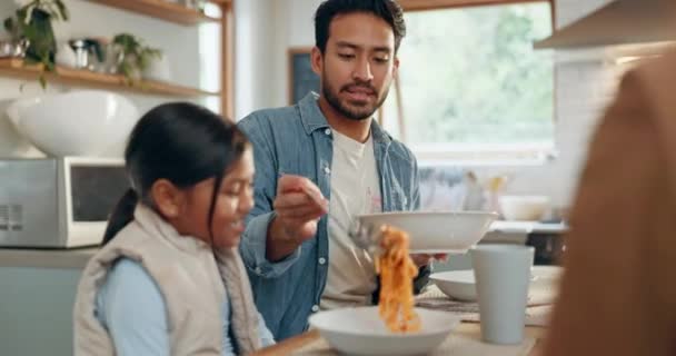 Vader, kinderen en een meisje eten spaghetti met haar familie in de eetkamer van hun huis samen voor het avondeten. Eten, kinderen en ouders rond een tafel voor een maaltijd, bonding tijdens het diner in een huis. - Video