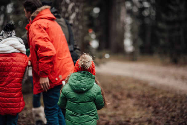 Boldog család ünnepli karácsonyi és újévi téli ünnepek szezonban szabadtéri. Aktív gyerekek a szülőkkel töltik az időt tűlevelű erdőben élvezik a gyermekkort - Fotó, kép