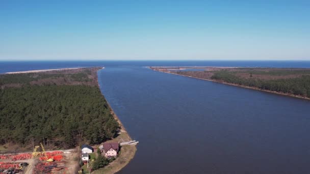 川の空中展望ドローンは海に入ります。ヴィスワ川のデルタはソビエセヴォ・グダニスク・ポーランドのバルト海に注ぐ。川の周りの森と小さな村 - 映像、動画