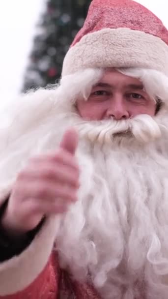 Porträt eines amerikanischen Weihnachtsmannes, der den Daumen hebt. Vertikales Video. - Filmmaterial, Video