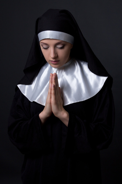 concepto de religión - retrato de joven hermosa monja ora sobre  - Foto, imagen