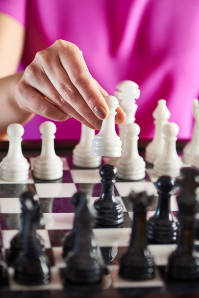 Mano con peón blanco sobre tablero de ajedrez
 - Foto, Imagen