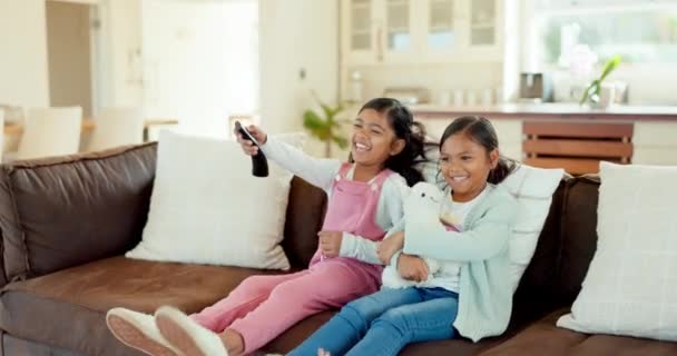 Happy, TV and children on sofa with remote for bonding, quality time and relaxing in living room. Family, childhood and happy girls on couch streaming cartoon movies, entertainment and kids series. - Footage, Video