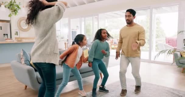 Parents, children and dance with a family in the living room of their home together for fun or bonding. Kids, funny or love with a playful mom, dad and sister siblings moving to music in their house. - Footage, Video