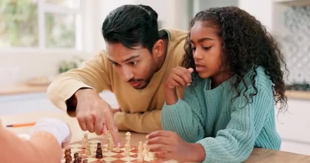 Familia, padre e hijo jugando al ajedrez en casa mientras enseñan o aprenden juegos de mesa. Hombre multiracial y pareja infantil juntos para jugar por diversión, jaque mate o competencia por el desarrollo y la vinculación. - Metraje, vídeo