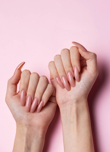 Γυναικεία χέρια με όμορφο μανικιούρ σε ροζ φόντο - Φωτογραφία, εικόνα