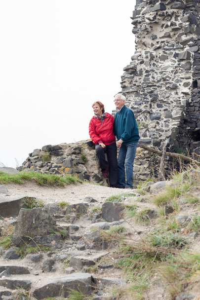 Túrázás a sziklás terep boldog idősebb pár - Fotó, kép
