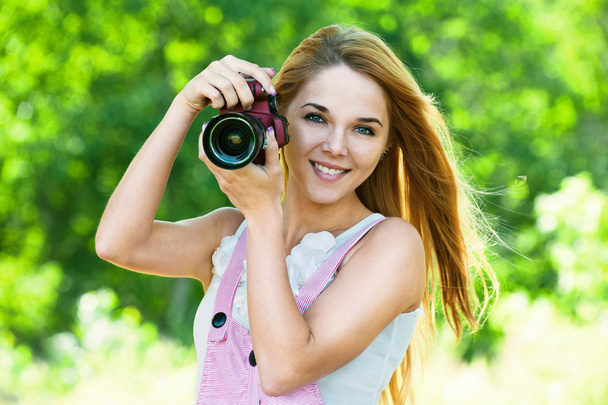 Beautiful woman holds camera - Foto, afbeelding
