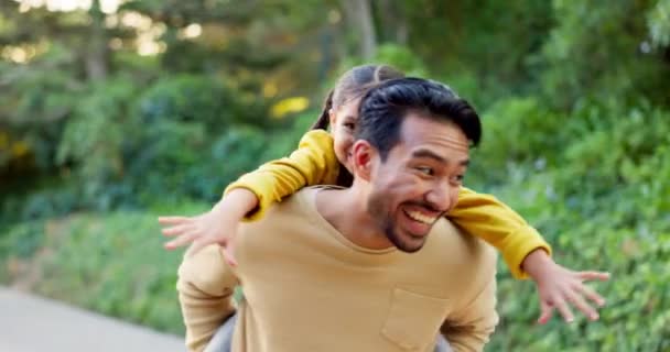 Happy, playful and a father and child in nature for walking, bonding and piggyback. Laughing, family and a young dad with a little girl in a park for weekend fun or activity together with freedom. - Footage, Video