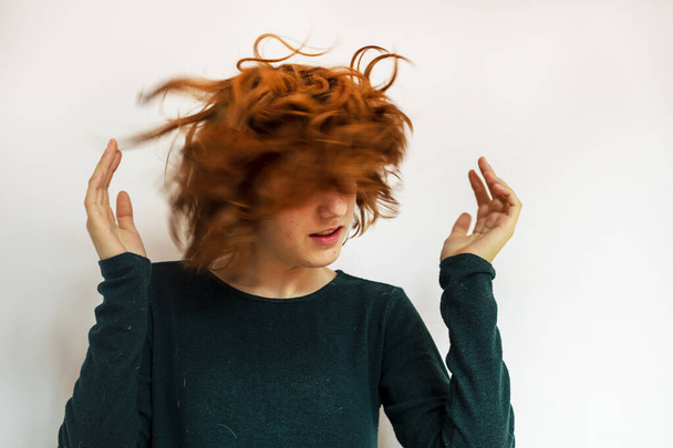 elegante ragazza adolescente scuote la testa in direzioni diverse con i capelli rossi - Foto, immagini