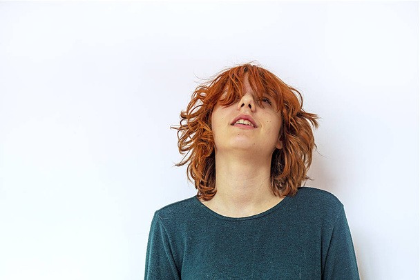 Şık genç kız başını kızıl saçlarıyla farklı yönlere sallıyor. - Fotoğraf, Görsel