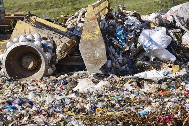 Ciężkie maszyny niszczą śmieci na składowisku odpadów na wolnym powietrzu. Gospodarka odpadami - Zdjęcie, obraz