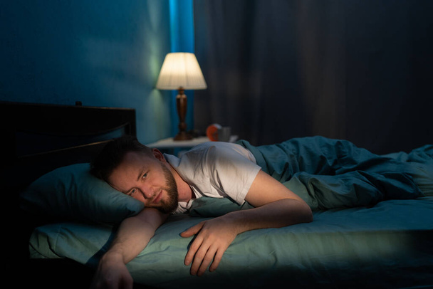 Homme insomniaque souffrant d'insomnie ou de stress. Fatigué et épuisé Réveillez-vous dans la nuit du problème. Espace de copie - Photo, image