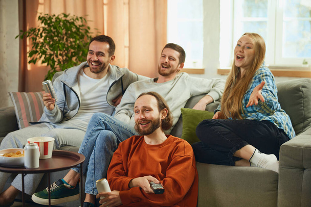 Group portrait of young people, friends watch film carefully and rejoice at happy and good ending of favorite comedy movie. Concept of friendship, togetherness, TV program, online event, recreation. - Photo, Image