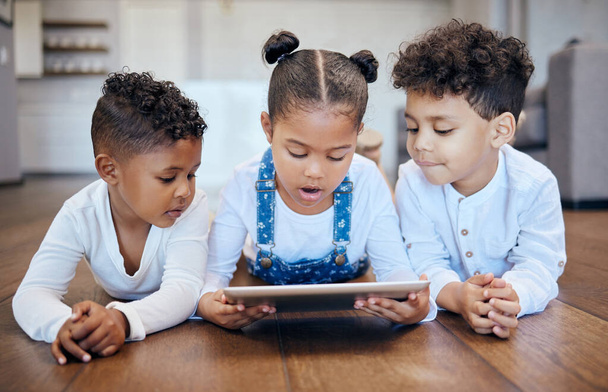 Dzieci, młodzież i tablet na piętrze w domu z aplikacją, rozrywką i internetem. Rodzeństwo, dziewczynka i chłopiec z technologią do nauki, razem lub nawiązywania więzi w dzieciństwie z online, gra lub web. - Zdjęcie, obraz