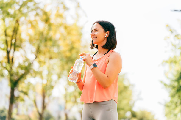 Женщина в хорошей форме держит себя в тонусе до и после занятий спортом на свежем воздухе утром. - Фото, изображение