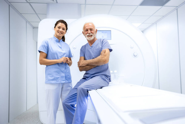 Portret uśmiechniętej lekarki i starszej pacjentki gotowej do wykonania badania MRI w szpitalu. - Zdjęcie, obraz