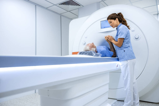 MRIスキャン手順前にシニア患者を快適にする女性医師. - 写真・画像
