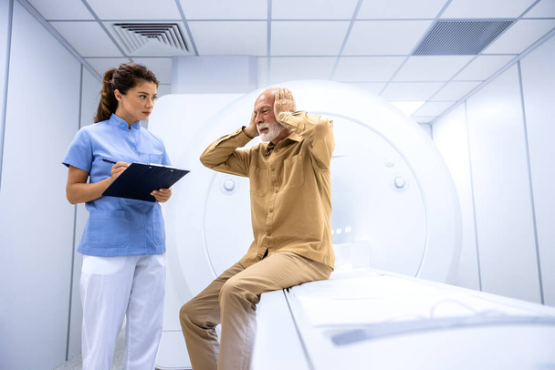 MRIスキャン検査前に強い頭痛を訴える患者. - 写真・画像