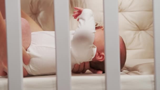 Kuvamateriaalia äiti laittaa pieni vauva tyttö sängyssä. - Materiaali, video