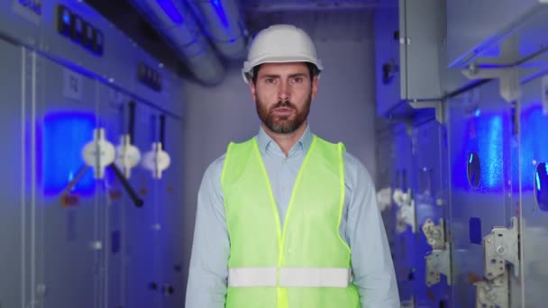 Portrét muže elektrotechnik pracovník v bílém hard hat rozvodny dělník gesta zastavit na pozadí modrého světla, vysokého napětí, a špatně fungující elektrické zařízení. - Záběry, video