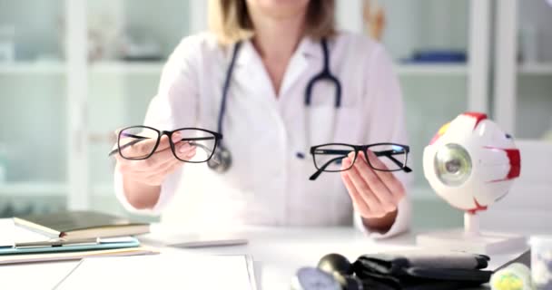 Oftalmólogo ofrece la opción de dos pares de gafas. Comprobación de la visión y concepto sanitario - Imágenes, Vídeo