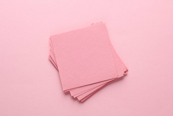 Stos różowy kwadratowy kartka papieru na różowym tle. Widok z góry - Zdjęcie, obraz