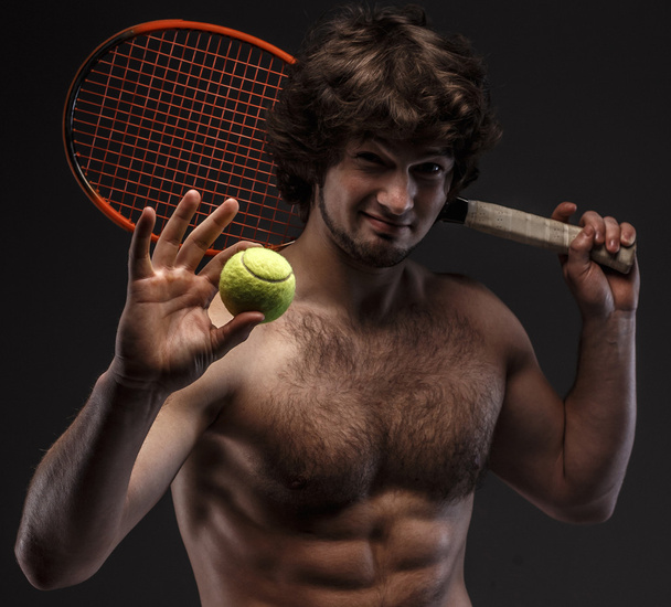 Чоловік з голим торфом і тенісною ракеткою
. - Фото, зображення