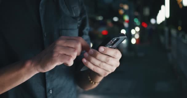 Erkek elleri, gece şehrin ışıklarının arka planındaki akıllı telefondan sosyal ağları tarıyor. Sosyal medya konsepti kaydırılıyor. Akıllı telefondaki mobil uygulama üzerinden erkek kaydırma haber kaynağı - Video, Çekim