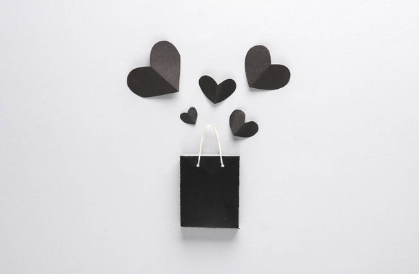 Sale, creatieve lay-out. Zwarte boodschappentas en hartjes. Zwarte vrijdag. Bovenaanzicht - Foto, afbeelding