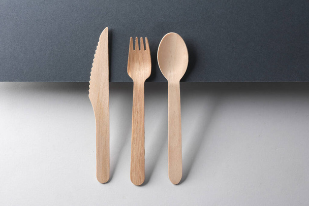 fourchette, cuillère et couteau en bois sur fond noir et gris. Mise en page créative. Composition minimaliste. Concept écologique - Photo, image