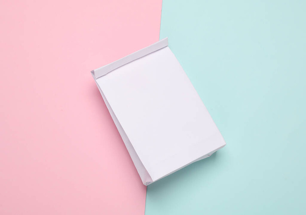 Mockup saco de almoço de papel branco no fundo azul rosa. Modelo para design. Vista superior - Foto, Imagem
