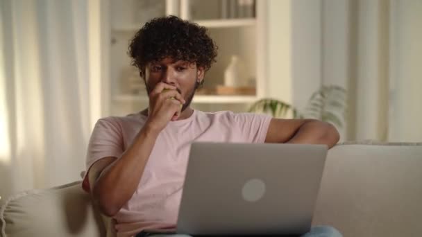Jovem freelancer cara nutrição estilo de vida saudável. Homem comendo maçã verde ao assistir vídeo no laptop. Estudante do sexo masculino rindo usando computador ao almoço. Revisão de filme e mordendo frutas. 4k de alta qualidade - Filmagem, Vídeo