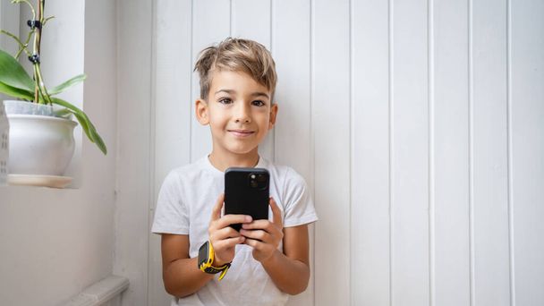 One small caucasian boy hold mobile phone smartphone take photos - Photo, Image