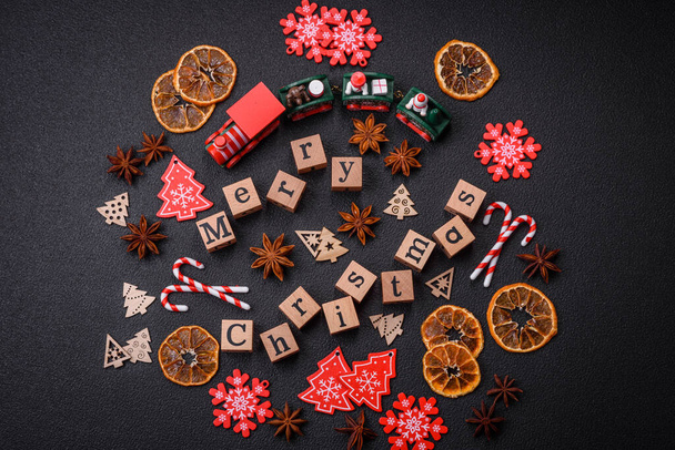 Beautiful Christmas composition with copy space with an inscription in wooden cubes on a black concrete background - Photo, Image